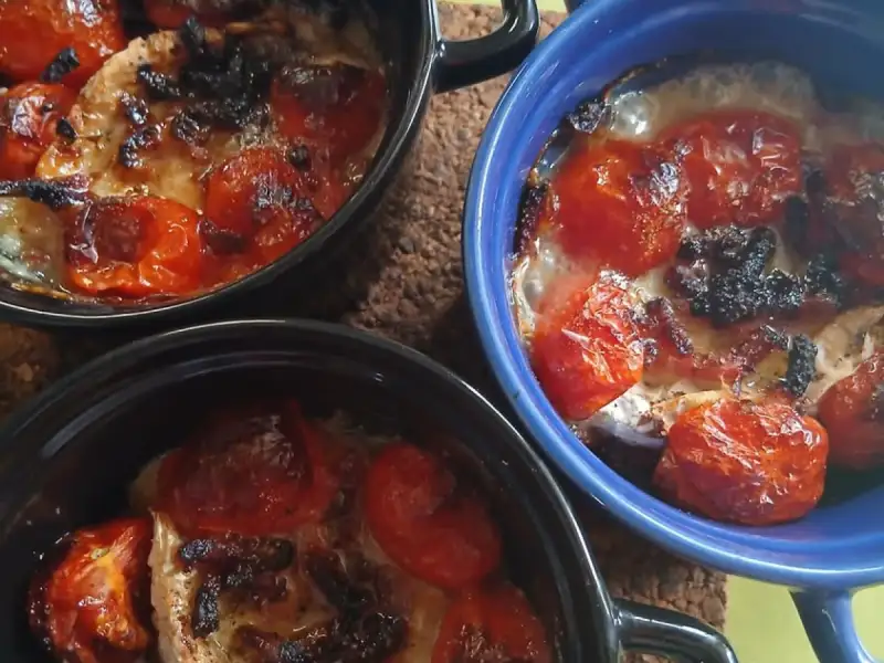 Tres cazuelitas de pollo con tomates cherry asados y mozzarella gratinada recién salidas del horno
